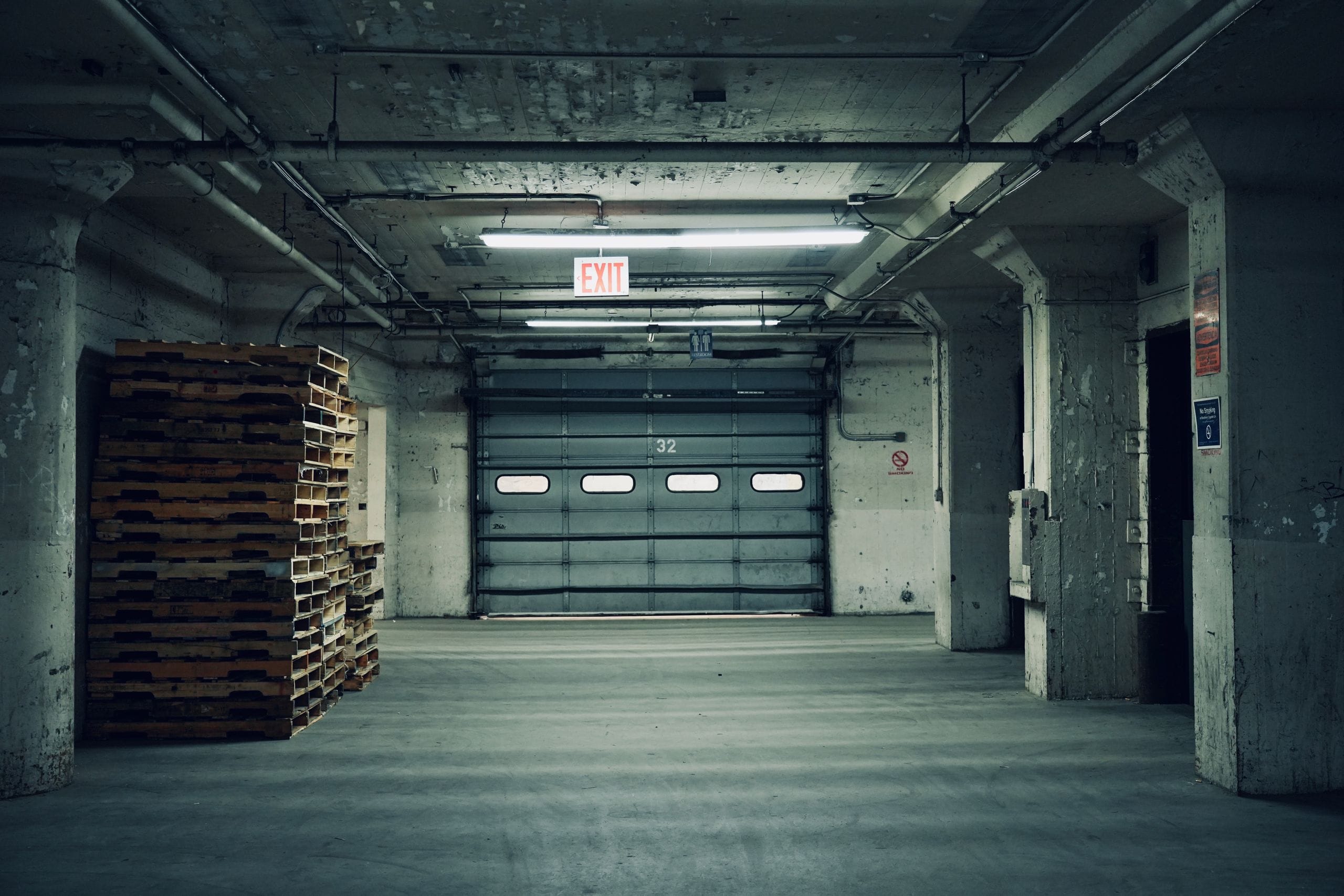 Loading dock and roll-up door inside a commercial building with stacked pallets